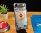 木桌上的透明 iPhone Air，显示内部组件和铜质充电线圈。 图片来源：Phone Repair Guru via YouTube