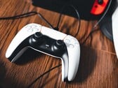 一张 PS5 手柄旁边放着 Nintendo Switch 的图片