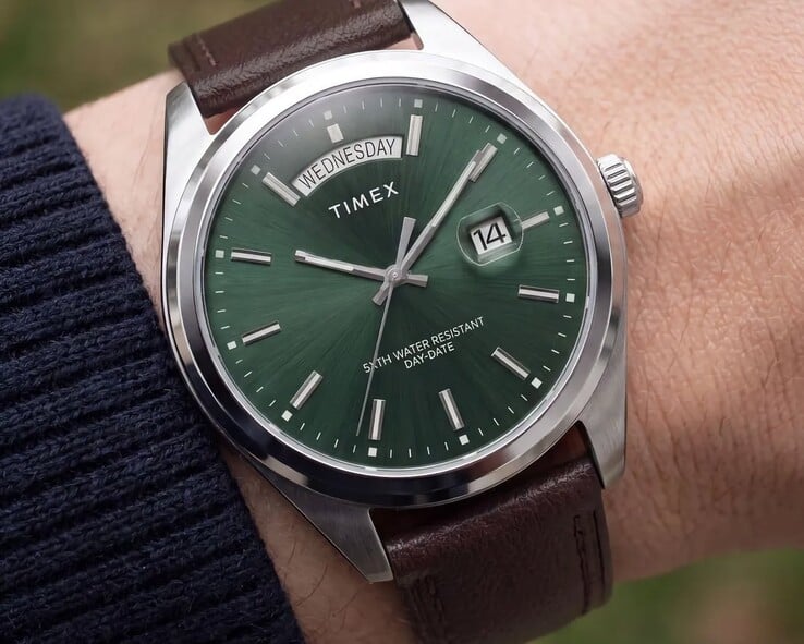 佩戴在手腕上的 Timex Legacy Day and Date 腕表,配有绿色太阳纹表盘。