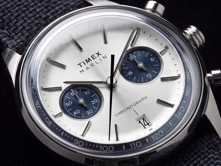 Timex Marlin Jet 计时码表 TW2Y89900 的特写镜头，展示了其银白色表盘、海军蓝小表盘、镶嵌式时标、棒形指针、测速刻度以及日期窗口。