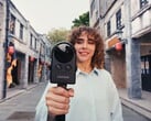 一名女子一边在街上行走，一边用Portalcam拍摄