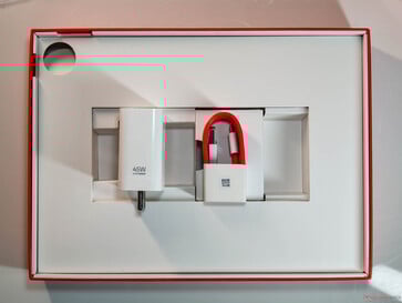 包装盒内还附有 45 W 充电器、USB Type-A 转 Type-C 连接线和 SIM 卡弹出工具（用于 5G 版本）。(图片来源：Notebookcheck）