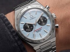 Timex Q Timex Continental 计时码表 TW2Y92400 佩戴于手腕的特写镜头,该表款采用冰蓝色放射状 CD 风格表盘、黑色副表盘、银色测速计表圈以及一体式不锈钢表链。