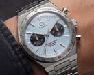 Timex Q Timex Continental 计时码表 TW2Y92400 佩戴于手腕的特写镜头,该表款采用冰蓝色放射状 CD 风格表盘、黑色副表盘、银色测速计表圈以及一体式不锈钢表链。