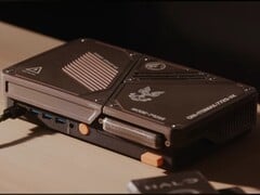 一款定制的紧凑型游戏主机,配备迷你电脑、外露的散热孔、USB接口以及橙色的电源按钮,置于桌面上。
