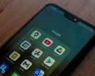 放在木质桌上的智能手机,屏幕上显示着已打开的 Google 应用文件夹