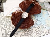 金色 Noah × Timex Boatswain 腕表，配有白色罗马数字表盘和黑色皮革表带，置于航海图和编织藤条上拍摄。