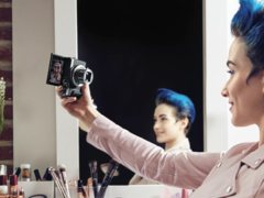 手持佳能 PowerShot 小型相机的女子