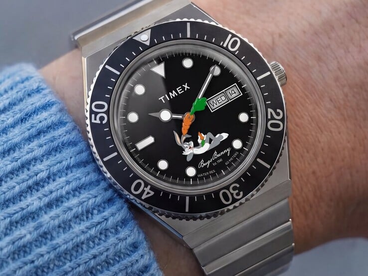 佩戴在手腕上的 Timex Looney Tunes x M79 Automatic，展示了其黑色表盘上的兔八哥图案、胡萝卜形秒针、星期日期显示以及黑色旋转表圈。