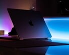 昏暗的房间里，一台半开着的 MacBook，光线从缝隙中溢出，洒在桌面上