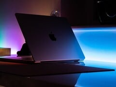 昏暗的房间里，一台半开着的 MacBook，光线从缝隙中溢出，洒在桌面上