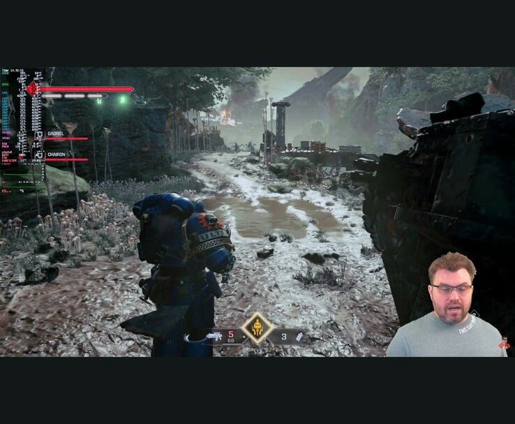 战锤 4 万太空陆战队 2》的游戏场景,屏幕上显示性能指标,YouTuber 在测试过程中出现在角落里。(图片来源:The Phawx via YouTube)