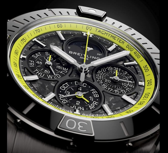 Breitling Super Chronomat B19 44 万年历计时腕表特写，展现其碳纤维表盘、日历小表盘、银色指针和青柠绿色测速刻度。
