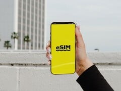 一只手拿着智能手机,黄色屏幕上醒目地显示着“eSIM”字样。