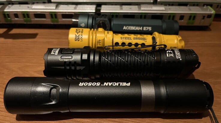 Loop Gear 的黄色 SK-07 与 Acebeam E75(后方)、Nitecore P27i 以及 Pelican 5050R 的对比
