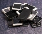 灰色的表面上堆放着一堆报废的智能手机