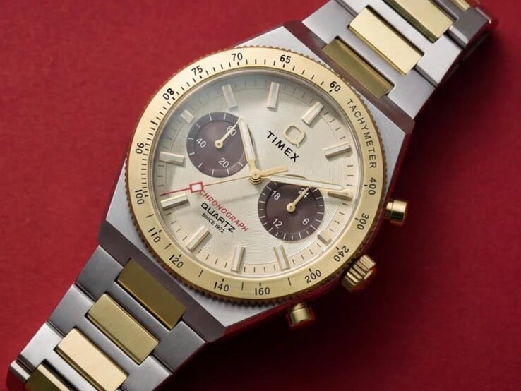 Timex Q Timex Continental 计时码表 TW2Y92300 佩戴在手腕上的特写镜头,展示了其金色表盘、棕色小表盘、测速计表圈以及双色不锈钢表链。