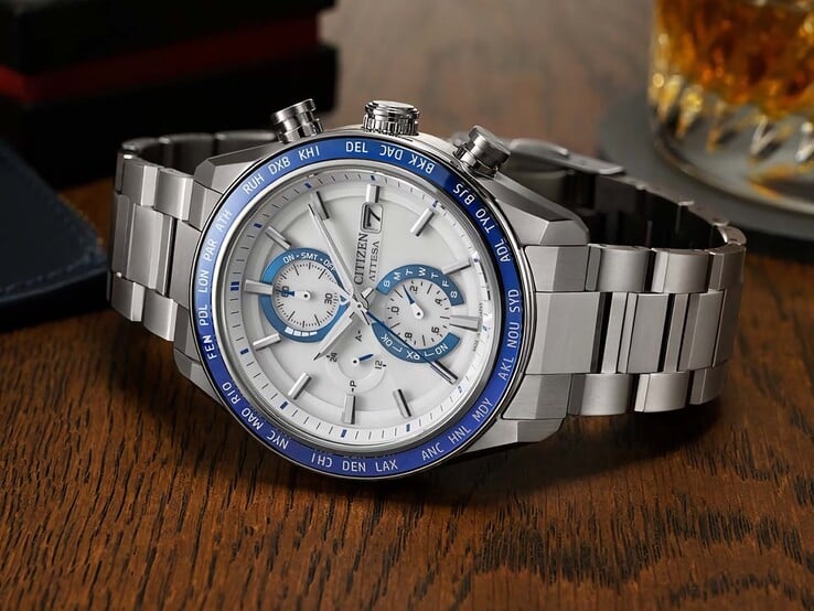 Citizen Attesa AT8297-51L 计时腕表置于木桌上，展示其海军蓝表盘、玫瑰金细节和黑色世界时区表圈。