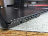 笔记本电脑上，两个USB-C接口旁边有一个圆柱形连接器