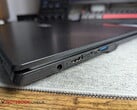 笔记本电脑上,两个USB-C接口旁边有一个圆柱形连接器