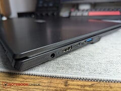 笔记本电脑上,两个USB-C接口旁边有一个圆柱形连接器